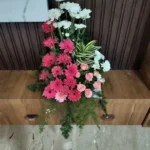 Pink gerbera and white flower table arrangement for housewarming ceremony